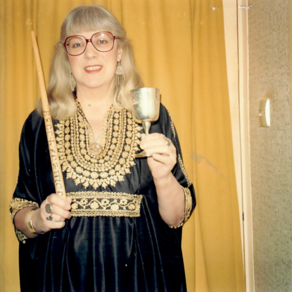 Doreen-holding-wand-and-chalice-infront-of-yellow-curtain