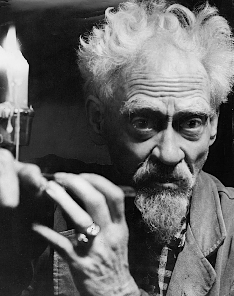 Gerald Gardner looking off behind the camera with candle to the- eft